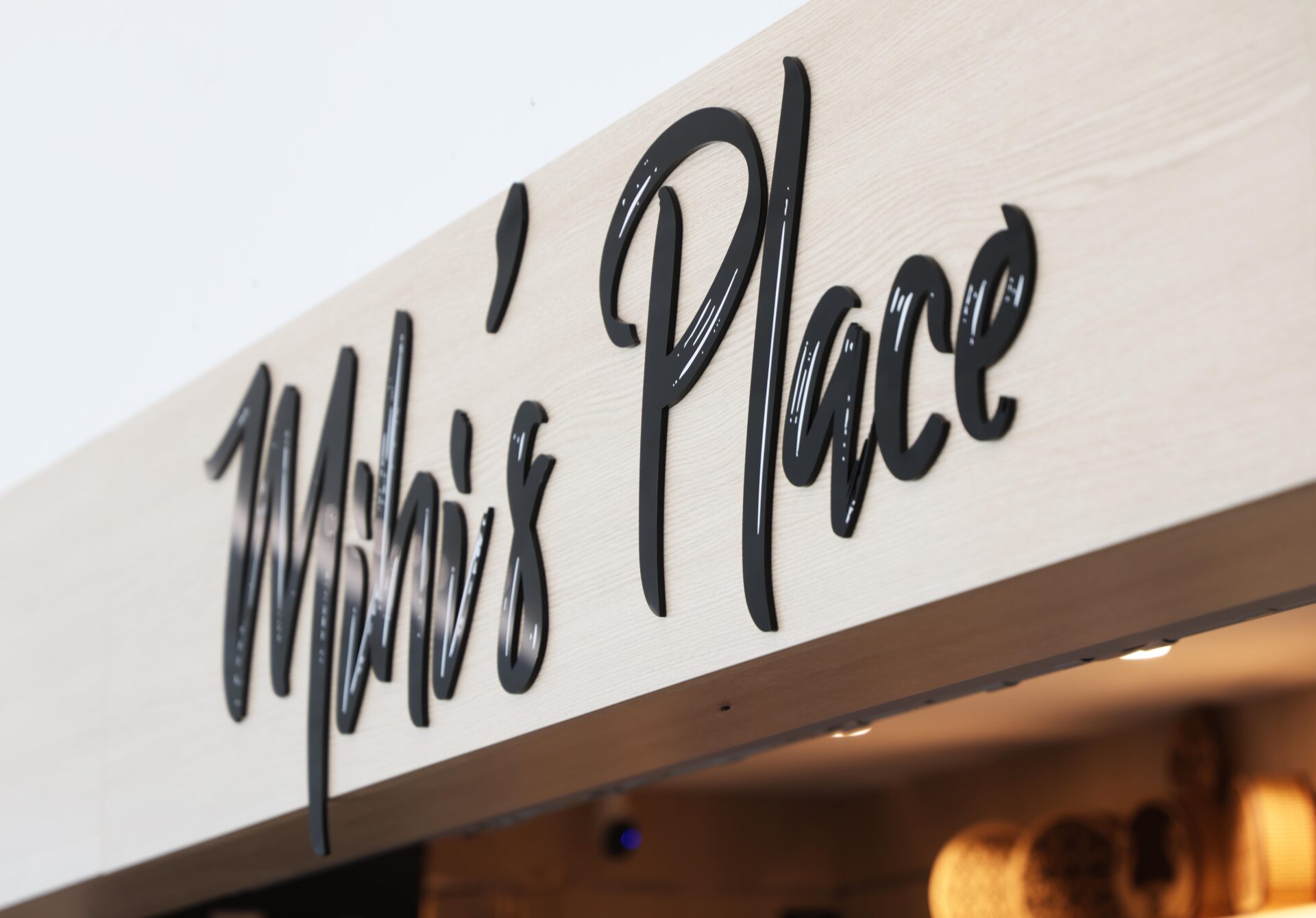 Custom black acrylic bulkhead sign at Mihi’s Place