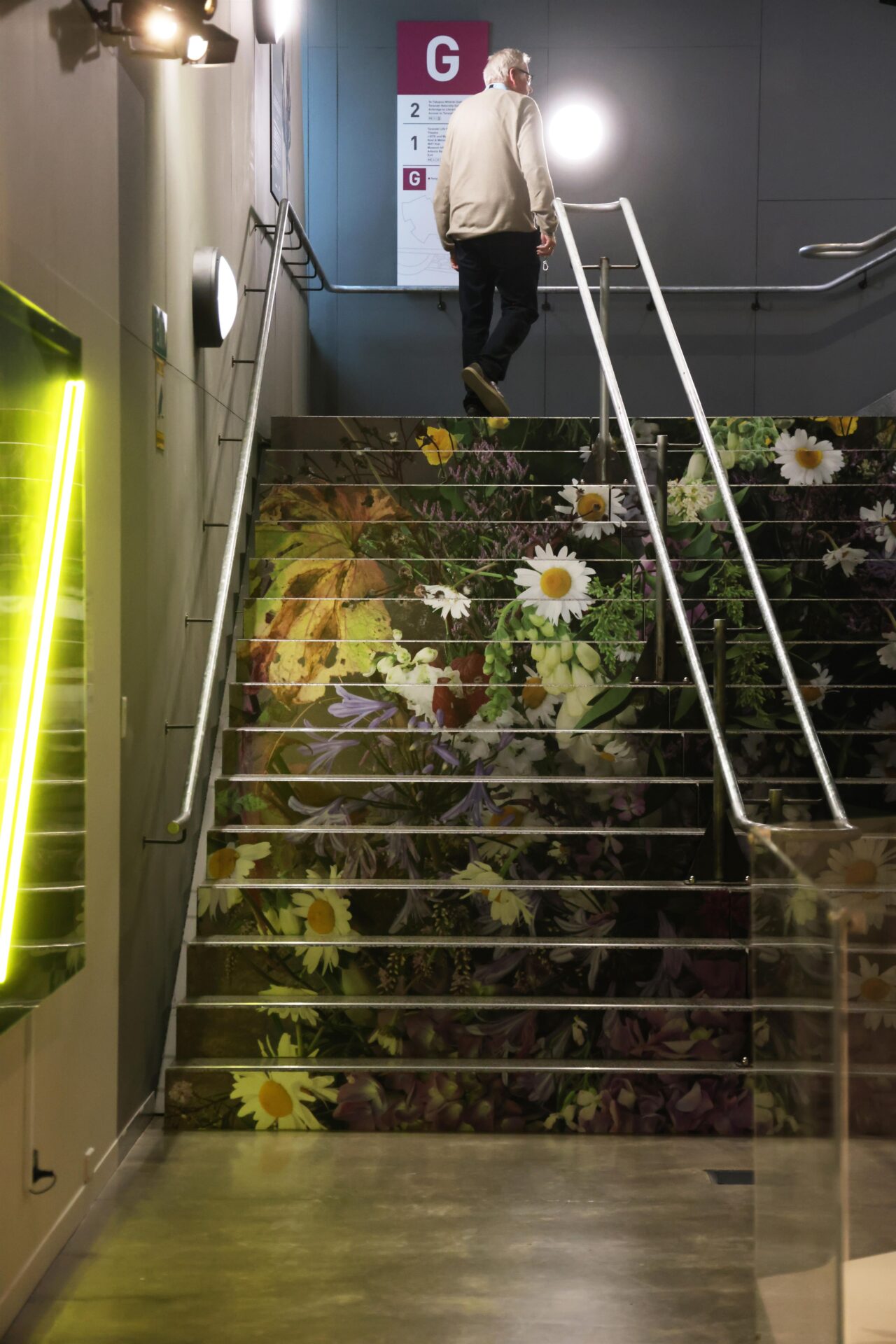 Stair mural showcasing enlarged botanical artwork in the exhibition space